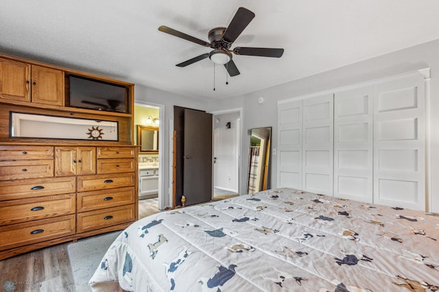 bedroom with hardwood / wood-style floors, ceiling fan, connected bathroom, and a closet