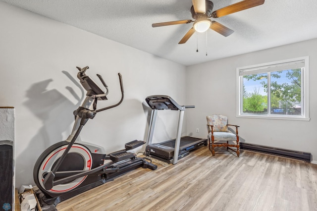 workout area with ceiling fan, a textured ceiling, and light wood-type flooring