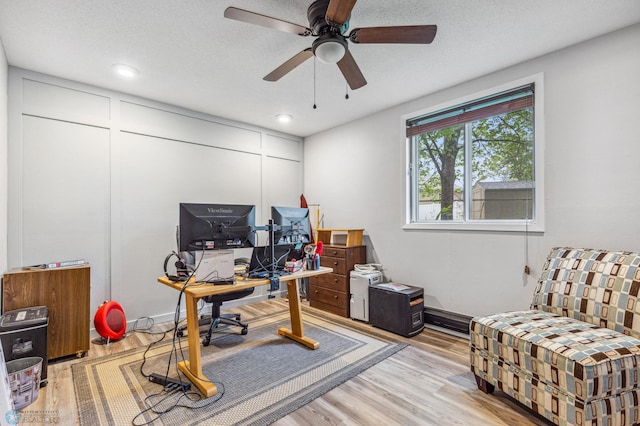 office area with ceiling fan, a textured ceiling, and light wood-type flooring