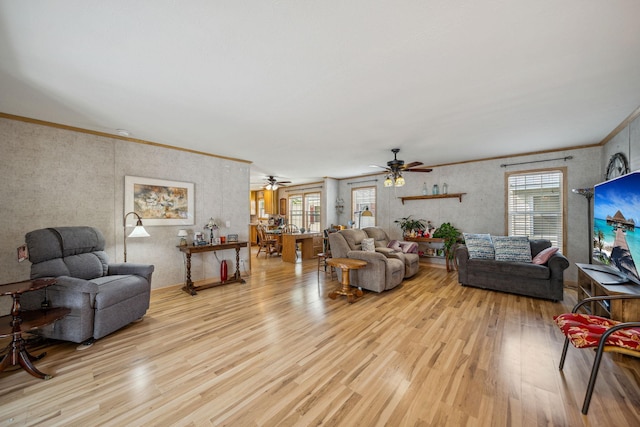 living room featuring crown molding, ceiling fan, and light hardwood / wood-style flooring