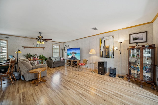 living room with ceiling fan, ornamental molding, and light hardwood / wood-style flooring