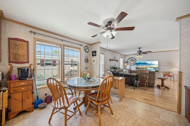 dining space featuring light wood-type flooring, crown molding, and ceiling fan