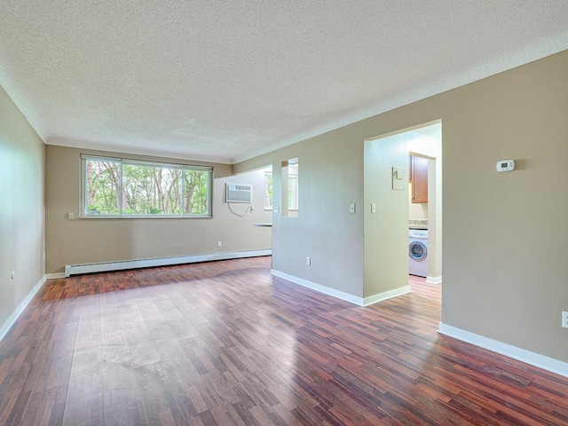 empty room with dark hardwood / wood-style flooring, a textured ceiling, a baseboard radiator, an AC wall unit, and washer / clothes dryer