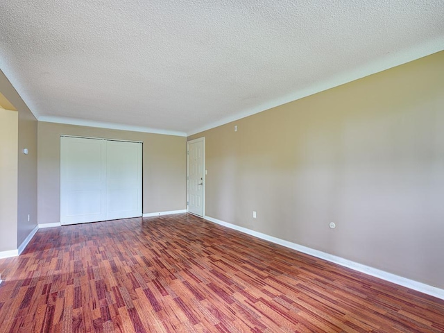 unfurnished bedroom with hardwood / wood-style flooring, a textured ceiling, and a closet