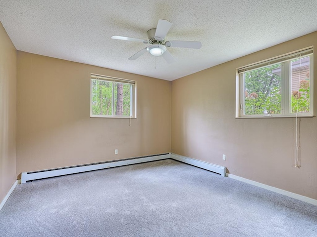 spare room with plenty of natural light, ceiling fan, light colored carpet, and a textured ceiling