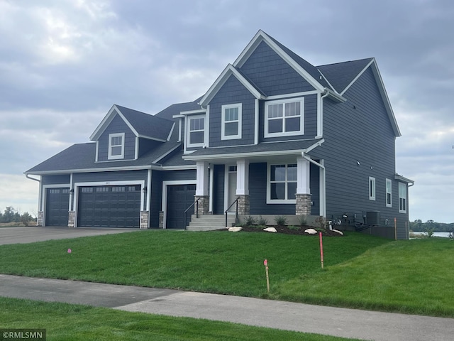 craftsman-style home featuring a porch, a garage, and a front yard