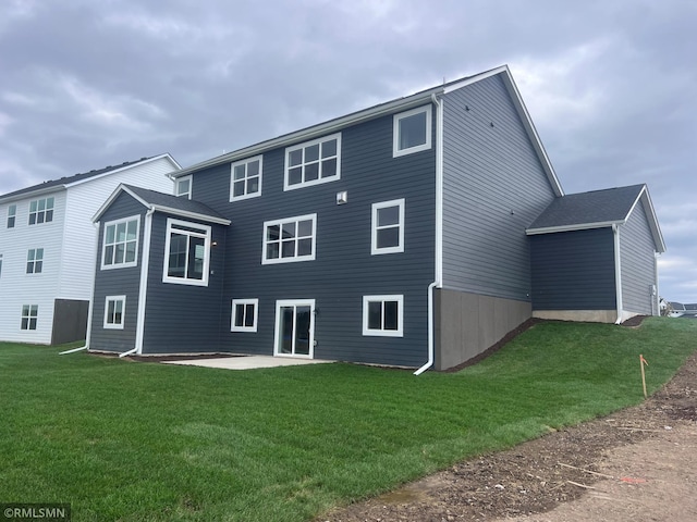 rear view of property with a lawn and a patio area