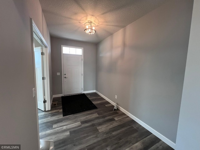 entrance foyer with a textured ceiling and dark wood-type flooring