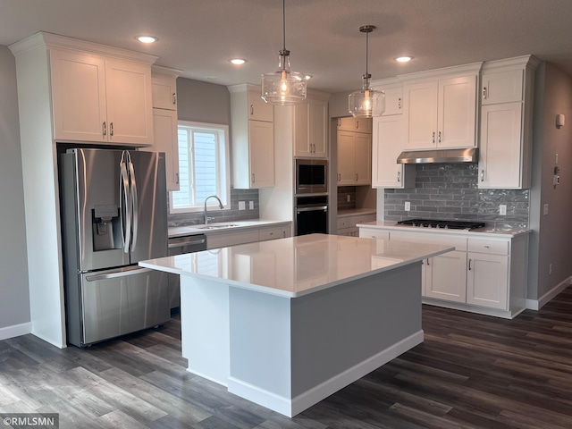 kitchen featuring sink, white cabinetry, hanging light fixtures, a kitchen island, and appliances with stainless steel finishes