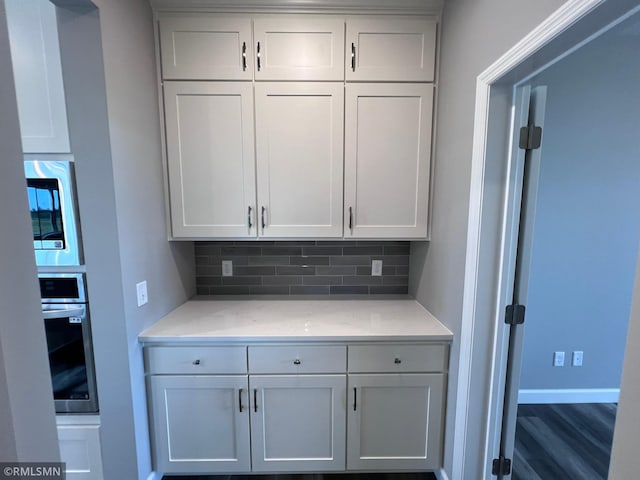 kitchen with stainless steel appliances, white cabinetry, and tasteful backsplash