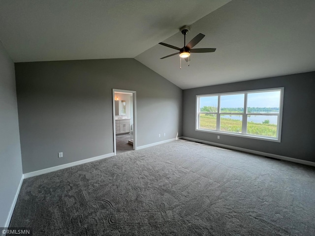 unfurnished room with lofted ceiling, dark colored carpet, and ceiling fan