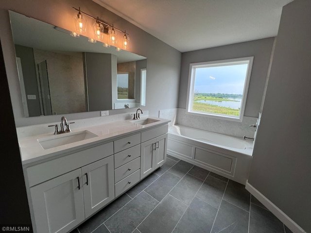 bathroom featuring a water view, vanity, a washtub, and tile patterned floors