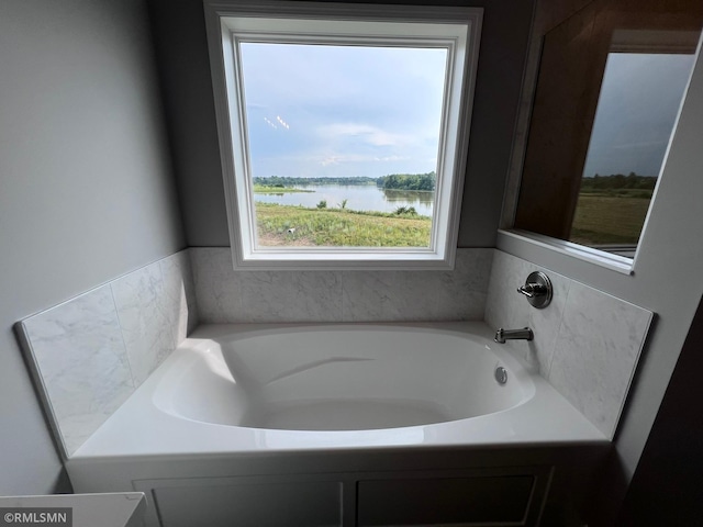 bathroom with a water view and a tub to relax in