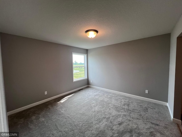 carpeted spare room featuring a textured ceiling