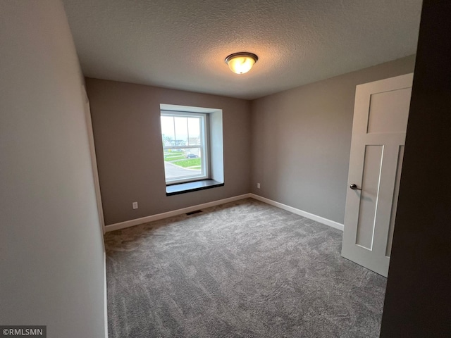 carpeted spare room with a textured ceiling