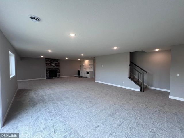 unfurnished living room with carpet floors and a fireplace