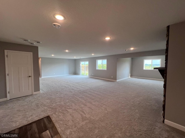 basement with light colored carpet and a textured ceiling