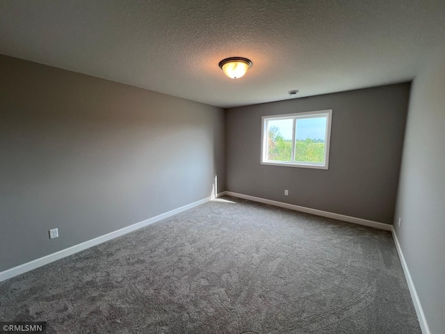 spare room featuring a textured ceiling and carpet