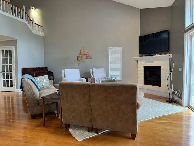 living room featuring a towering ceiling, hardwood / wood-style flooring, and a fireplace