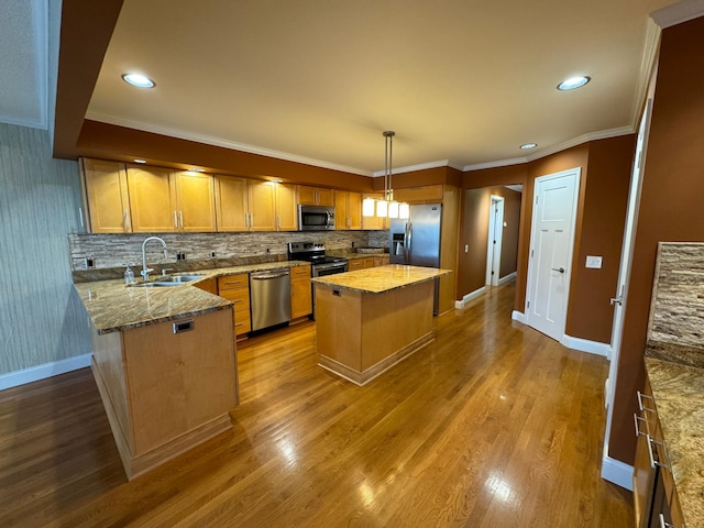 kitchen with a center island, appliances with stainless steel finishes, wood-type flooring, sink, and tasteful backsplash