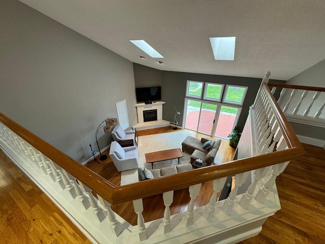 interior space featuring wood-type flooring and vaulted ceiling with skylight