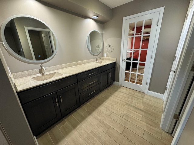 bathroom featuring hardwood / wood-style floors, oversized vanity, and double sink