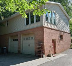 view of property exterior featuring driveway and brick siding