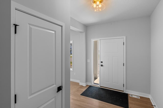 foyer with light hardwood / wood-style floors and a textured ceiling