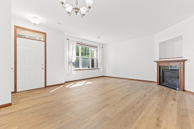 unfurnished living room featuring light hardwood / wood-style flooring and an inviting chandelier