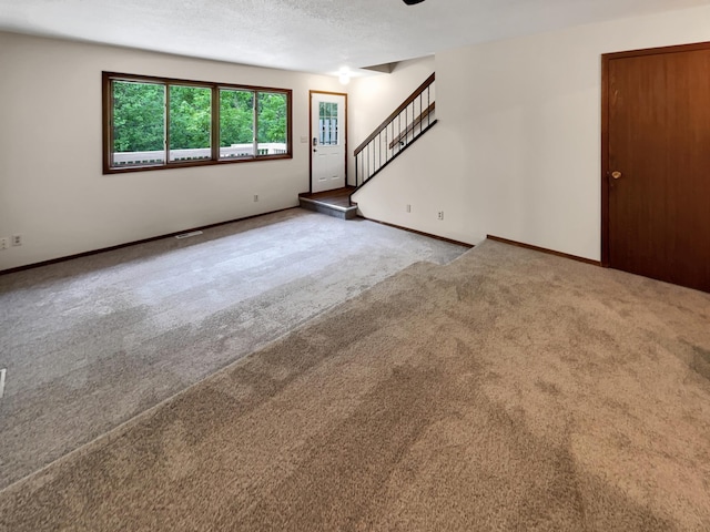 unfurnished room featuring a textured ceiling and carpet flooring