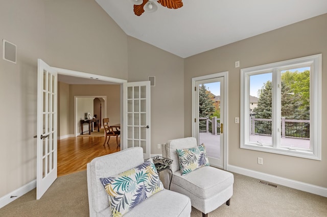 living area featuring carpet flooring, ceiling fan, vaulted ceiling, and french doors