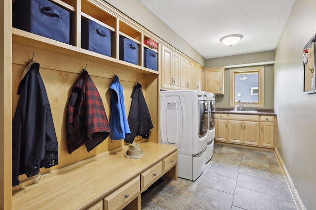 clothes washing area with cabinets, independent washer and dryer, a textured ceiling, and sink