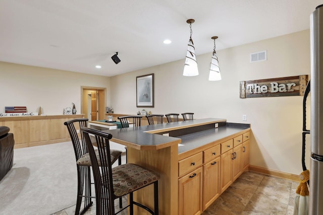 kitchen featuring pendant lighting, a kitchen breakfast bar, and kitchen peninsula