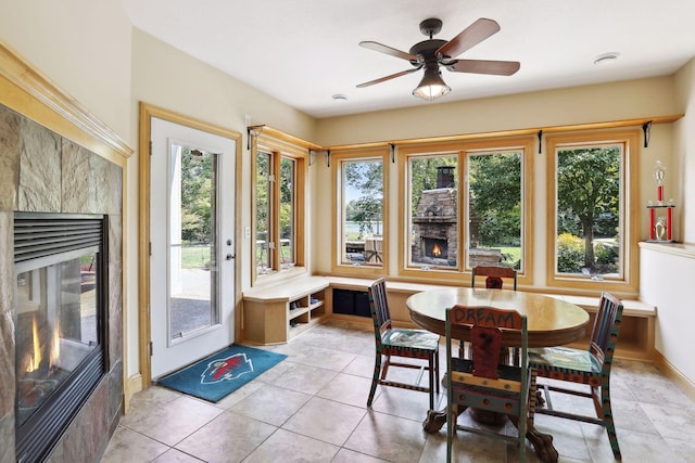 sunroom / solarium featuring a fireplace, plenty of natural light, and ceiling fan