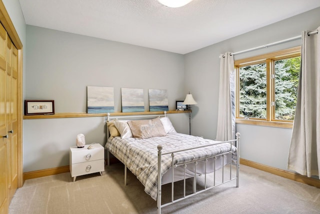 carpeted bedroom with a textured ceiling and a closet