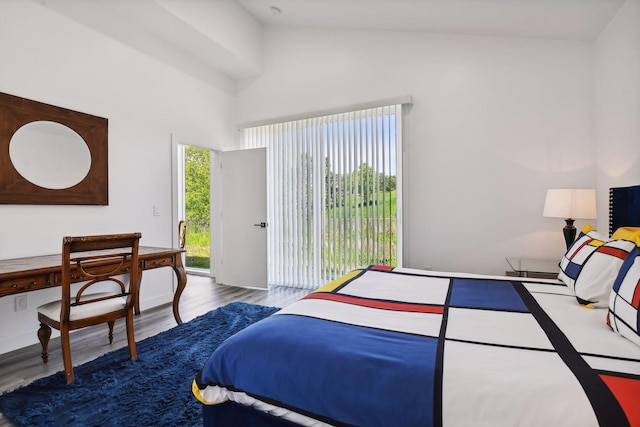 bedroom featuring wood-type flooring, multiple windows, and vaulted ceiling