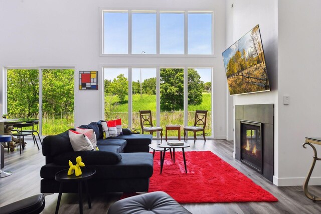 living room featuring a wealth of natural light, light wood-type flooring, and a tile fireplace