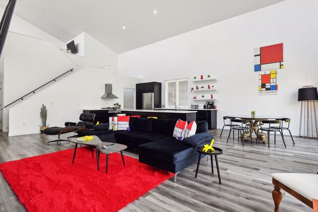 living room featuring light wood-type flooring and high vaulted ceiling