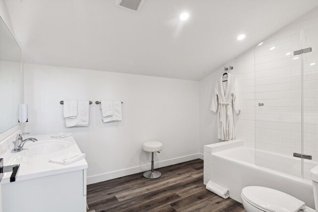 full bathroom with wood-type flooring, vaulted ceiling, toilet, shower / tub combination, and vanity