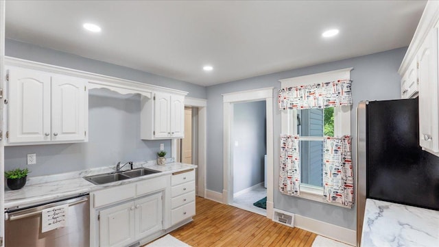 kitchen featuring sink, white cabinets, stainless steel appliances, and light hardwood / wood-style flooring