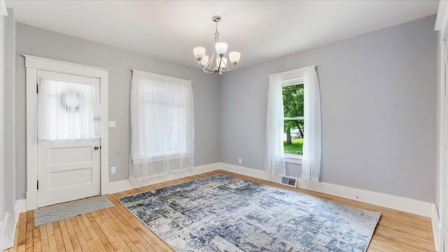 entrance foyer with hardwood / wood-style flooring and a chandelier