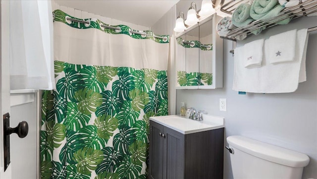 bathroom featuring a shower with curtain, vanity, and toilet