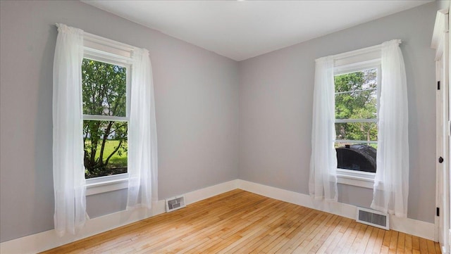 spare room with hardwood / wood-style floors and a wealth of natural light