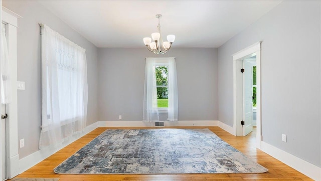 interior space with light wood-type flooring and a notable chandelier