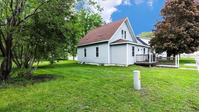 view of side of property with a lawn and a wooden deck