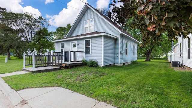 view of front of home with cooling unit, a front lawn, and a deck