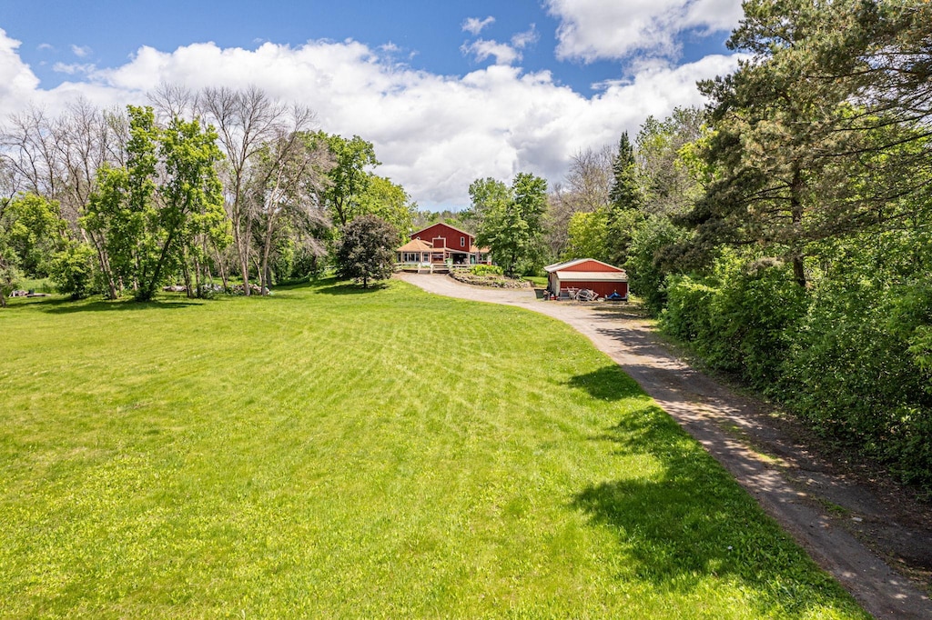 view of yard with a garage and an outbuilding