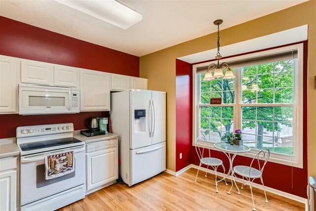 kitchen featuring light hardwood / wood-style flooring, a notable chandelier, white cabinetry, white appliances, and pendant lighting