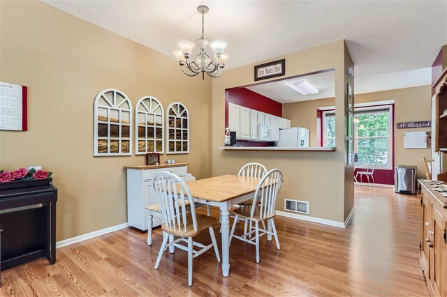 dining room featuring light hardwood / wood-style floors and an inviting chandelier