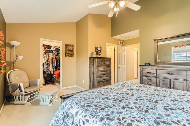 carpeted bedroom featuring vaulted ceiling, a spacious closet, ceiling fan, and a closet